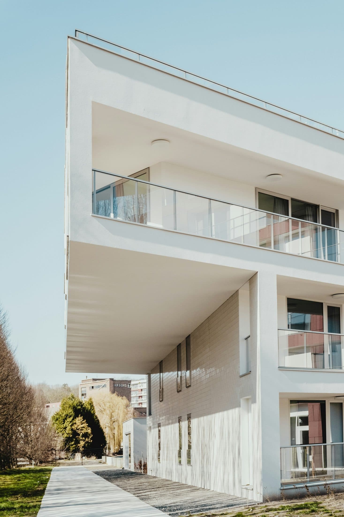 Demo image. White low-rise residential building with deep balconies.