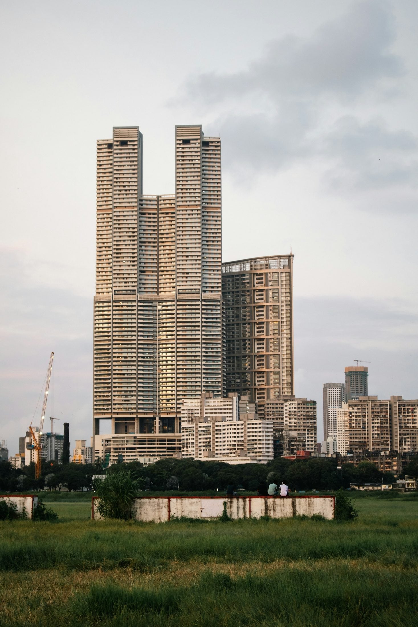 Demo image. Two residential towers rising beyond open ground.
