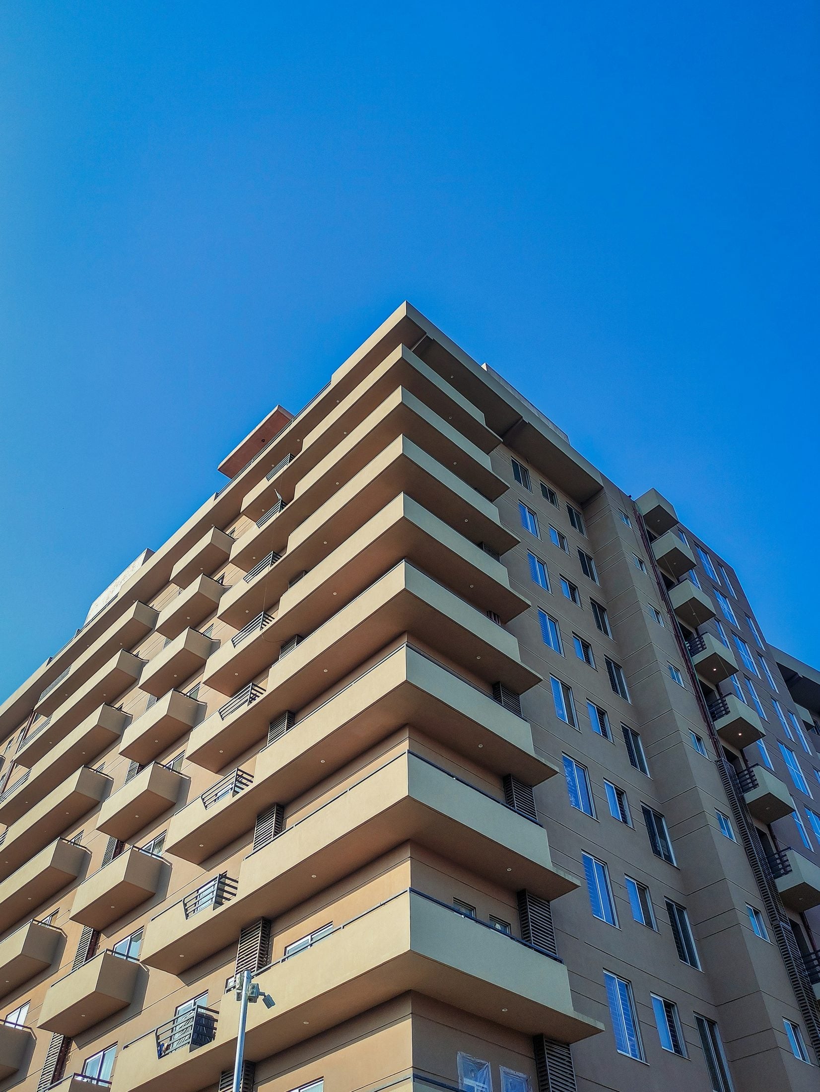 Demo image. Apartment building with tiers of balconies, seen from the street.