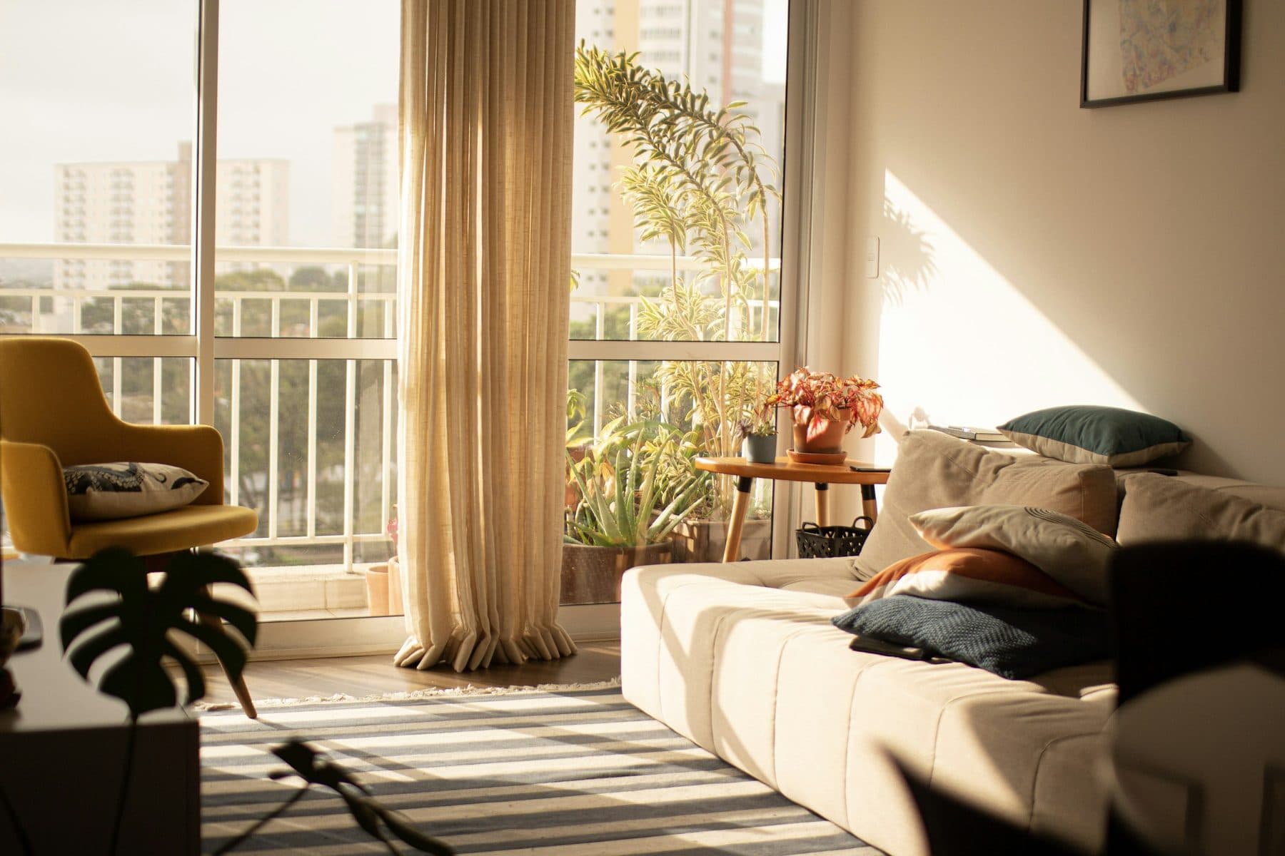 Demo image. Sunlit living room opening onto a planted balcony.